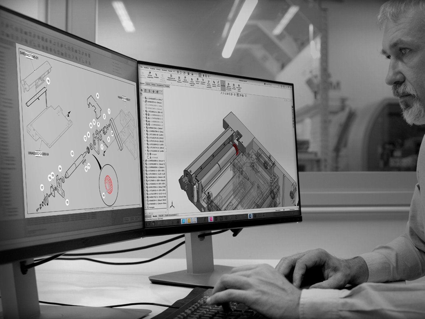 Progettista B2B al lavoro su doppio monitor con modelli CAD 3D e render esplosi per cataloghi e fiere.